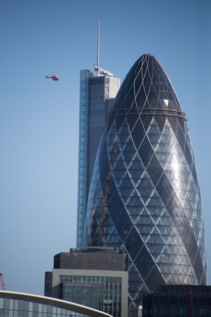 View of the Gherkin 30 St Mary Axe with the heron Tower behind and the air ambulance